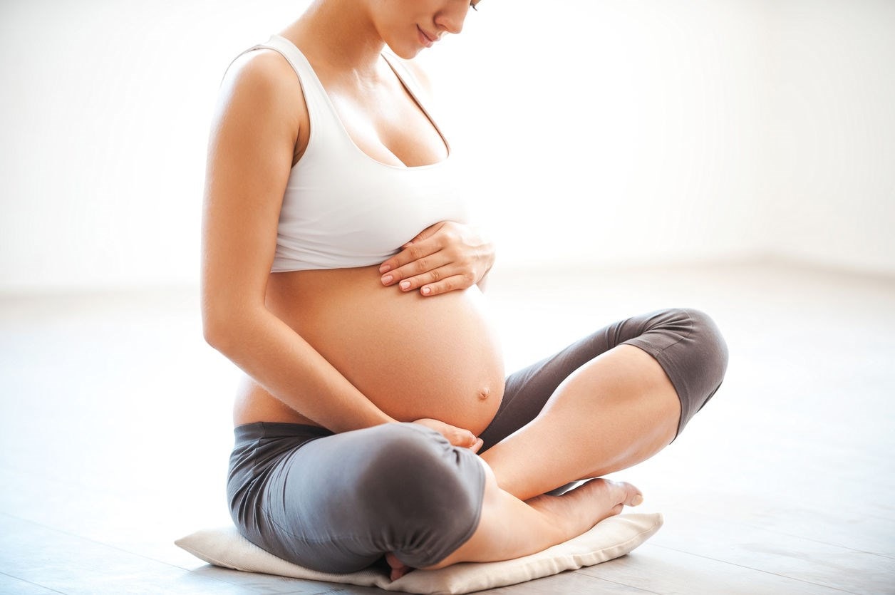 Pregnant woman holding her tummy 