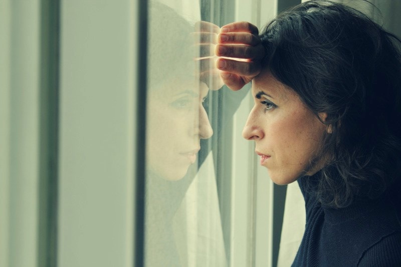 woman looking anxiously out the window